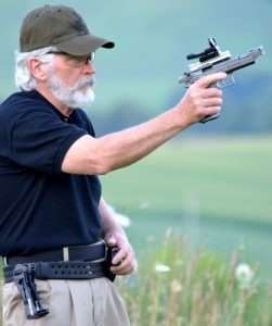 The author reaches for a fresh magazine mounted on the belt…