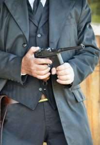 The holster design used was for an original Mauser C96, so the Umarex does not fit with the magazine attached (unless the holster had a cutout for the extended length of the magaizne. Here the author pulls a full magazine from his coat pocket and inserts it into the magazine well.