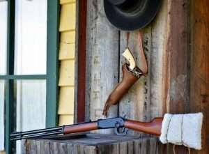 With a sheepskin tied around the stock to disguise the black plastic buttplate and the hood removed from the front sight, the Walther looks very much like an 1894 Winchester. (Shown with a custom holster by Chisholm’s Trail Leather, an Umarex Colt SAA, and “Bohannon” hat courtesy of Golden Gate Western Wear)