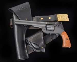 By 1874 the better handling S&W Schofield, as improved by U.S. Army Colonel George W. Schofield, was being adopted by the federal government. The first S&W large frame revolvers used by the U.S. Army in 1870 had been criticized for the top-break design, which had a barrel-mounted release latch that was often hard to use. Schofield redesigned the latch mechanism to fit the frame and release the barrel by simply pulling the latch back (with the hammer at half cock) and pressing the barrel down against one’s leg (or other surface) to pivot it open, thus automatically ejecting all of the spent casings for a quick reload, the gun’s greatest advantage over Colt revolvers. (.177 caliber Schofield by Bear River Outdoors, c.1875 Cavalry holster, military belt and buckle and cartridge pouch courtesy John Bianchi Frontier Gunleather)