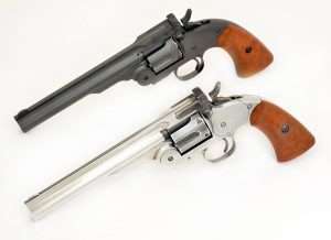 The original Bear River gun, top, and the refinished antiqued model are shown together. Note that the faux case colors on the latch go around the top of the barrel as it is a separate piece. The channel down the center of the barrel is also left darker as are the sides of the front sight. The polished top of the front sight easily picks up in the blued V notch of the stud latch. The polished cylinder still remains a couple of shades darker, especially inside the cylinder flutes.