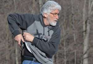 …The shirt must be held securely to avoid blocking the gun as it is withdrawn from the holster…
