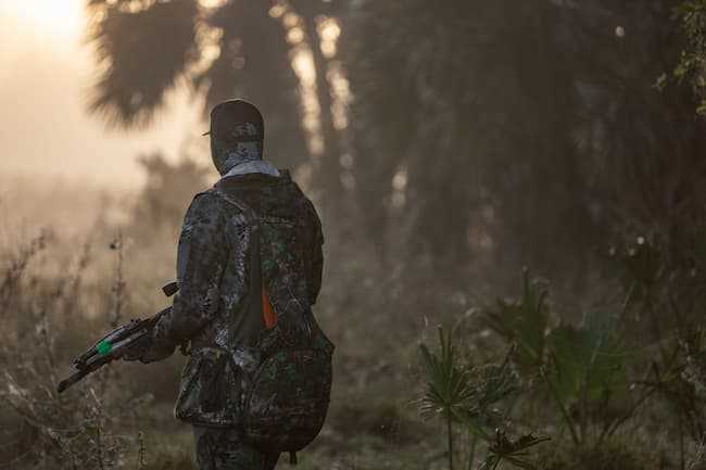 Hunter stalking through brush.