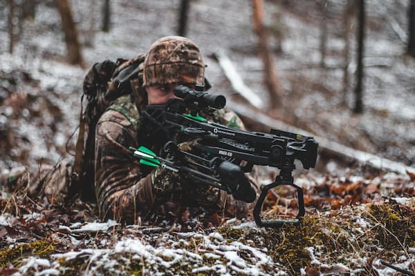 Hunter looking through scope of CenterPoint Wrath crossbow.