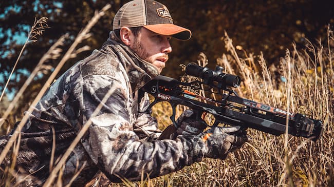 hunter with crossbow observing his quarry