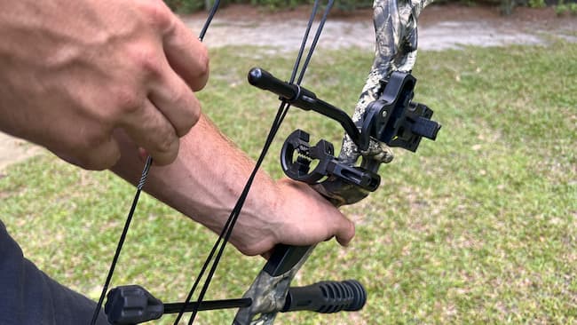 archer pulling back the bowstring of a compound bow
