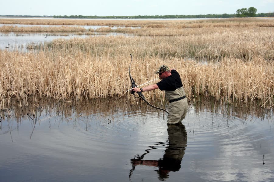 Kevin wading and waiting for carp to swim by and present a shot opportunity.