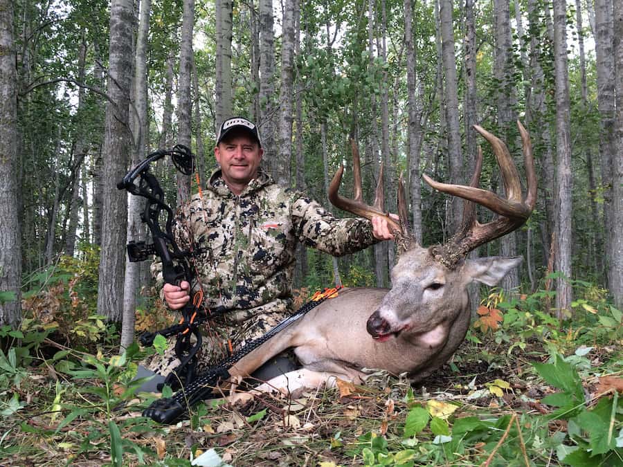 bowhunter posing with early season buck,