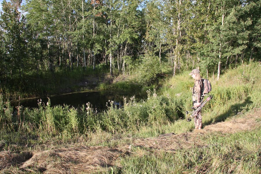 bow hunter overlooking watering hole