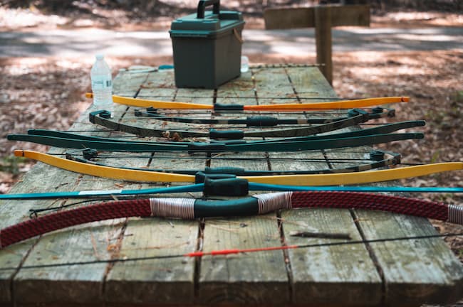 several traditional bows laid out on a park table