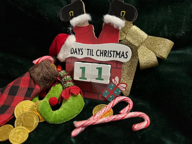 11 days till Christmas, stocking stuffers, chocolate coins, candy canes, and stuffed elf feet poking out the top of stockings.