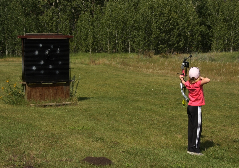 youth archer practicing aim with a compound bow 