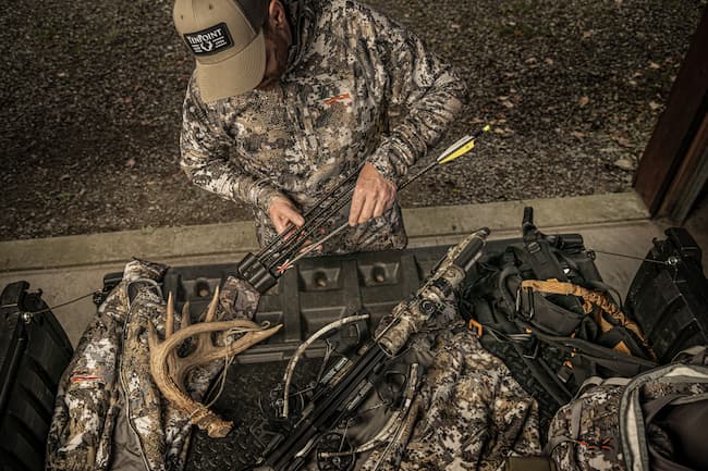 Archer sorting out arrows in a quiver.