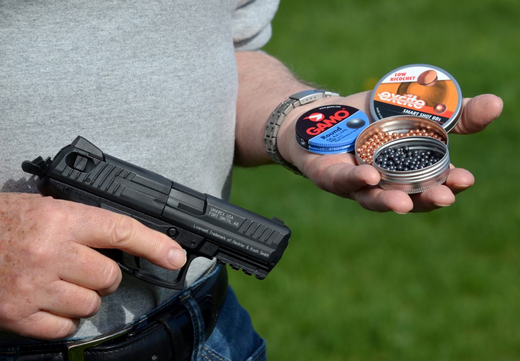 Denis Adler holding the pistol in his right hand and the BB tins in his left hand.