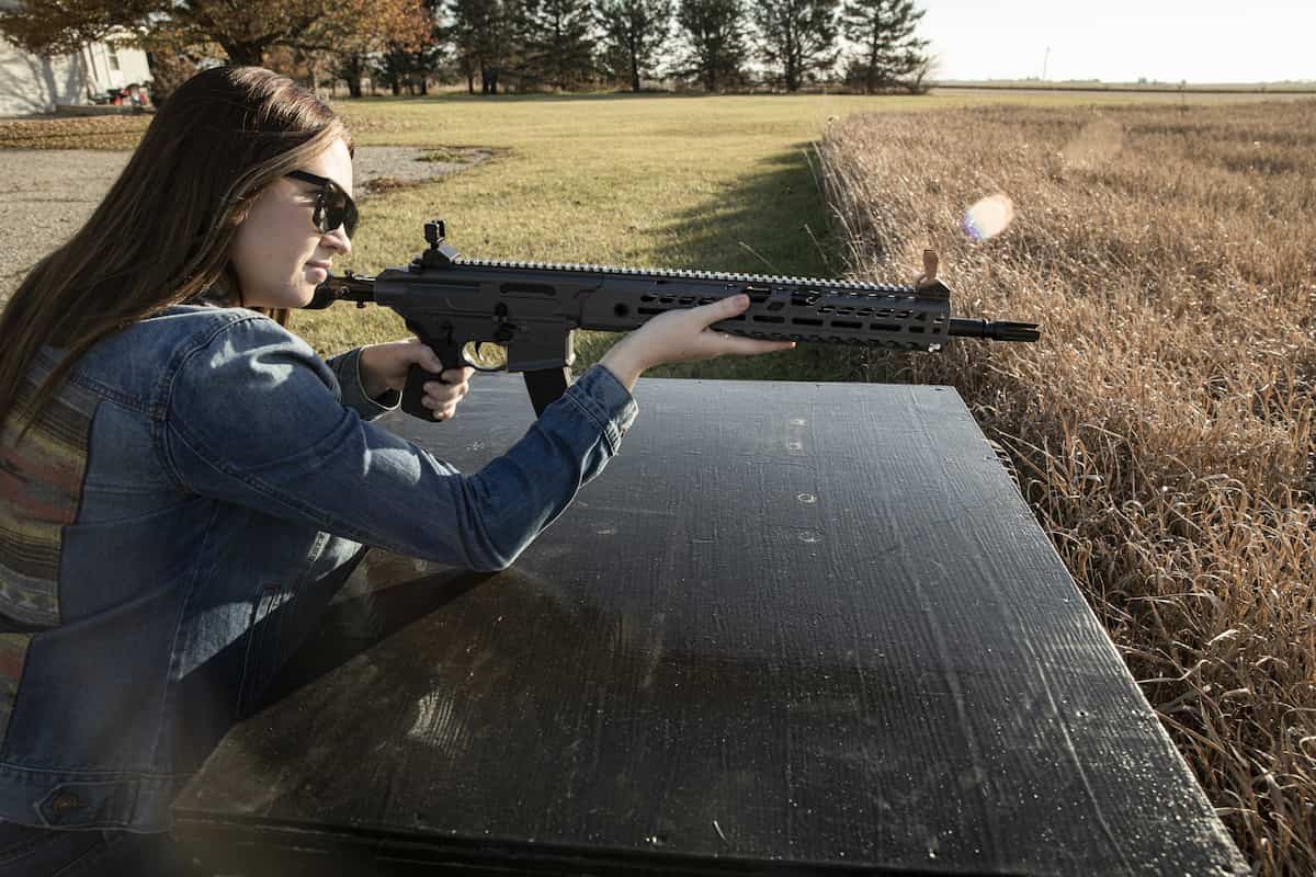 sunshine and shooting - female airgunner shooting a sig sauer mcx in her back yard.