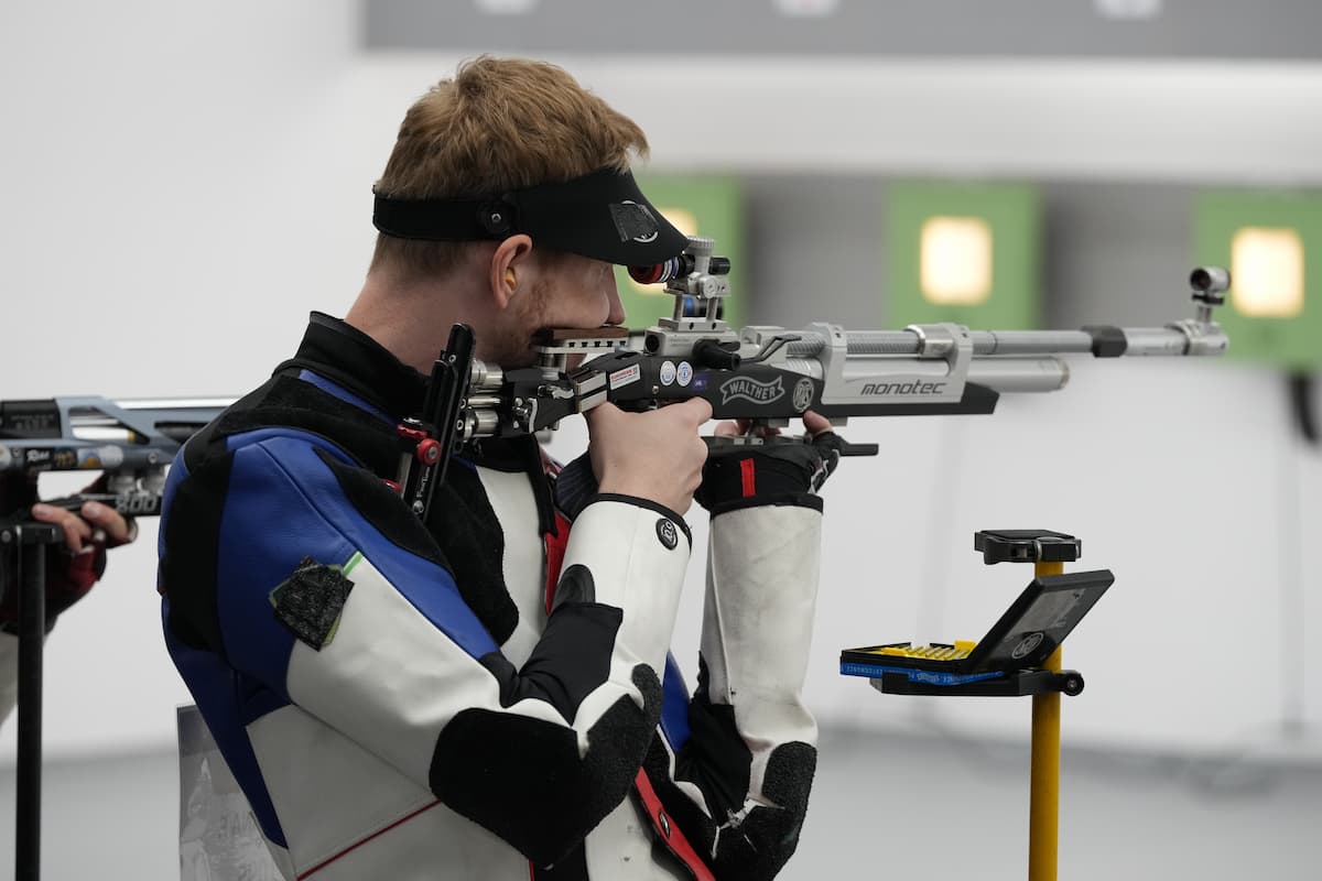 10-meter air rifle competitor at the firing line getting ready to take his shot