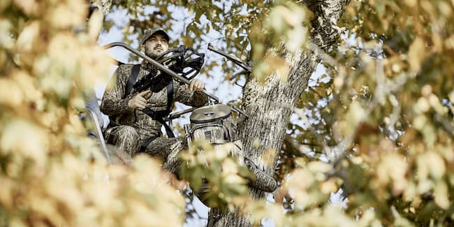 Hunter in a tree stand with a crossbow.