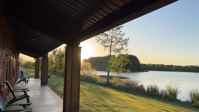 a covered concrete porch looking out over a picturesque lake.