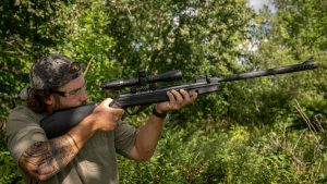 hunter using crosman air rifle to sight game