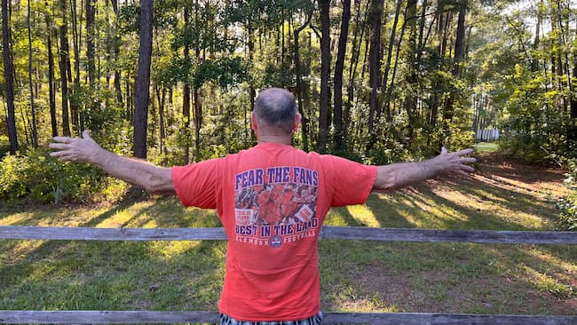 older man with arms stretched to show his "wingspan"