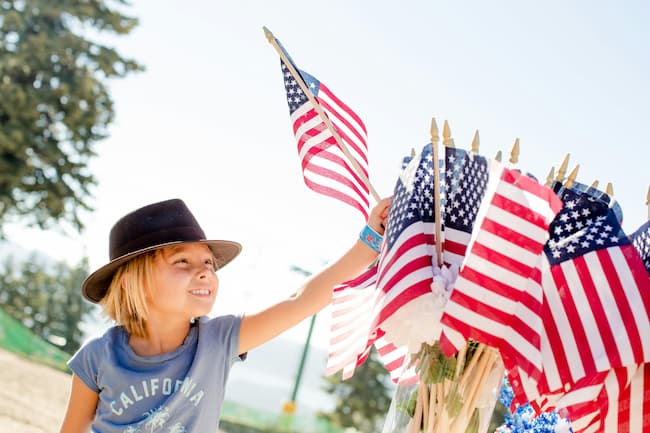 Fourth of July celebration, girl with group of american flags