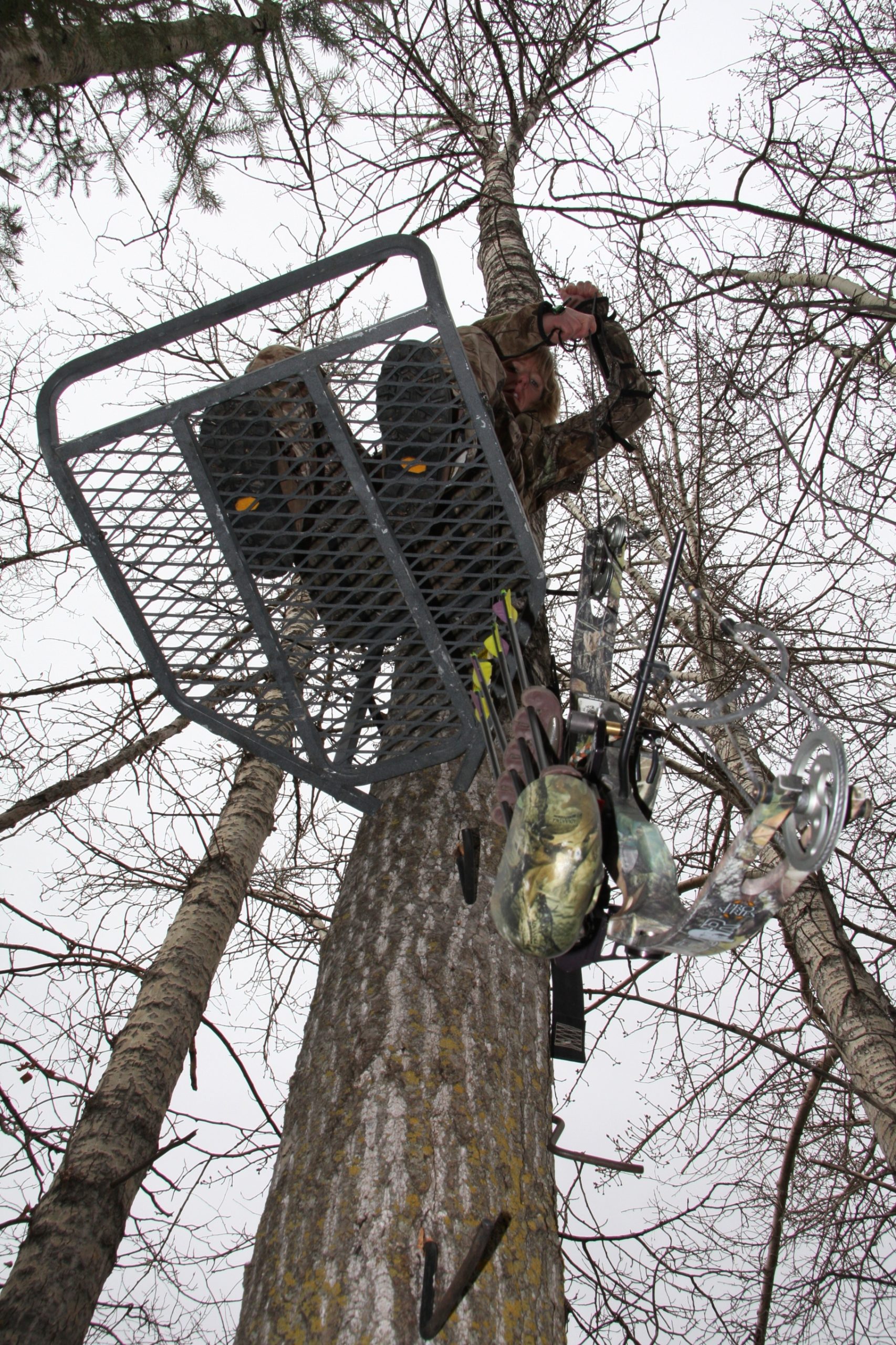 archer lowering equipment with a rope from a treestand
