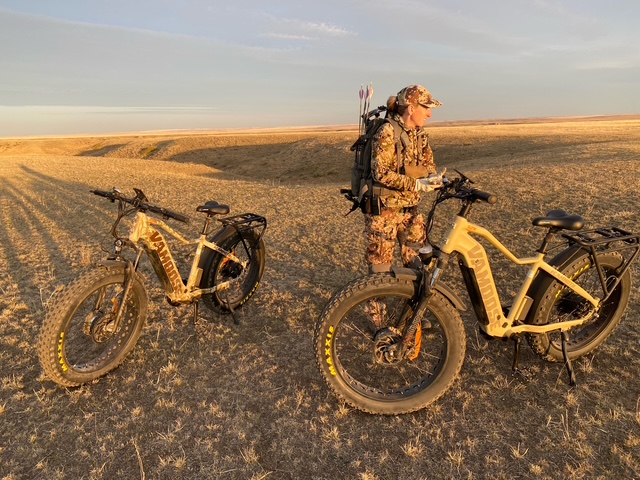 author's hunting partner with 2 ebikes set up on the trail